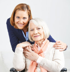 Smiling senior woman with caregiver from nursing service at home