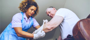 Nurse putting a bandage on a senior man's arm